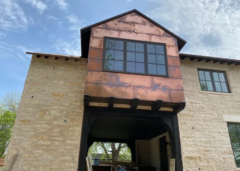 Copper metal panel facade on a stone building for Skylight Installation in Glenwood